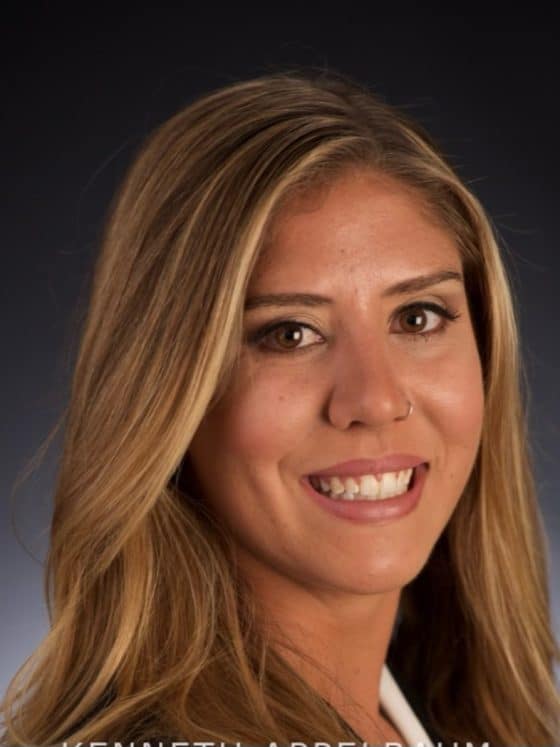 A blonde woman smiling on a gray background