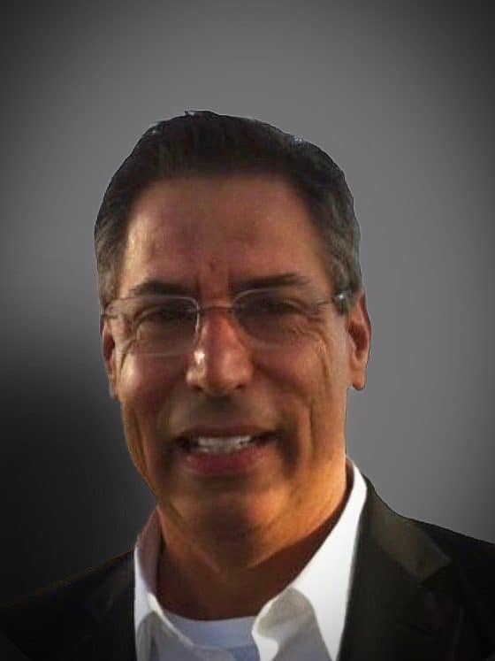 A middle-aged man smiling on a gray background.