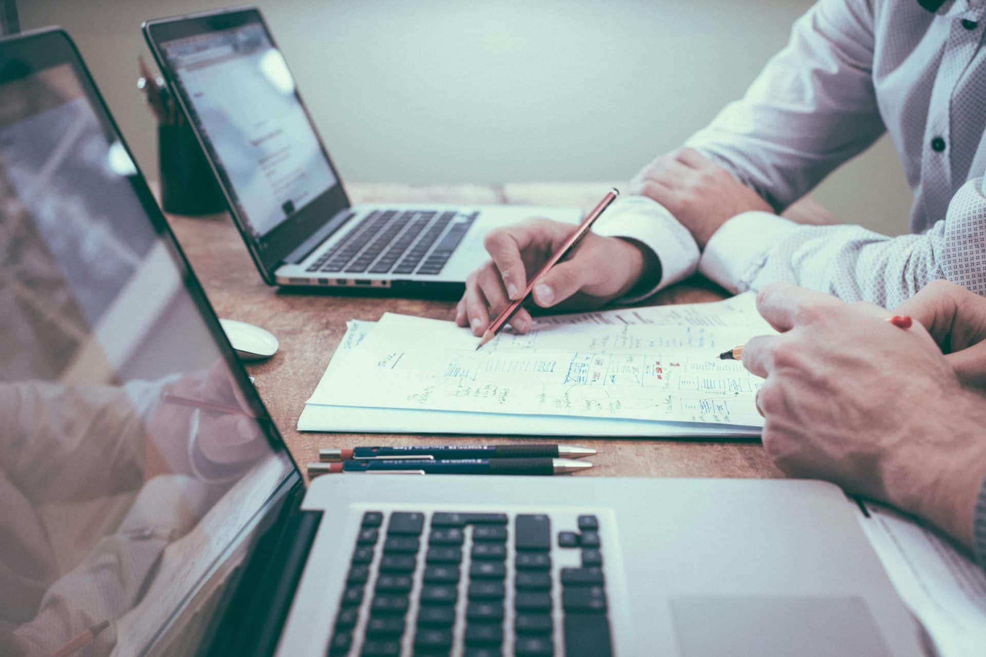 Person holding a pencil helping another person fill out a form.